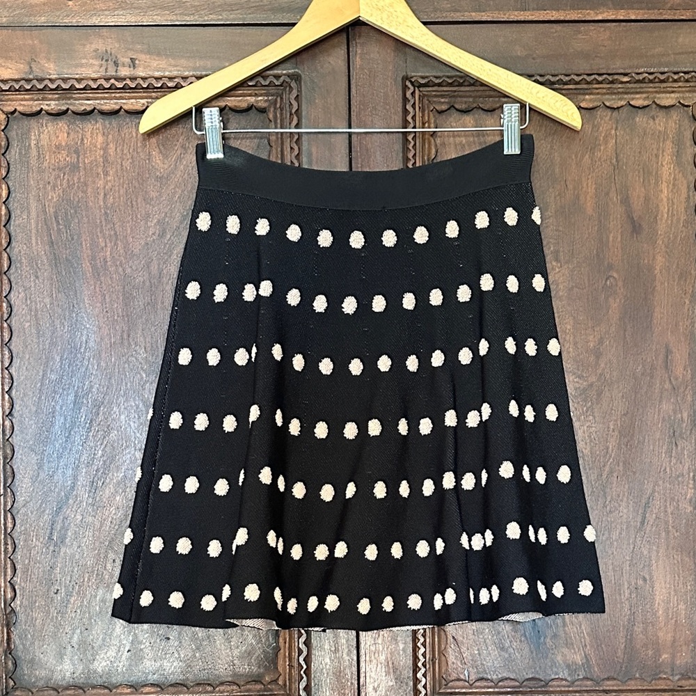 BCBG a-line black knit mini skirt with textured off white polka dots. Size s